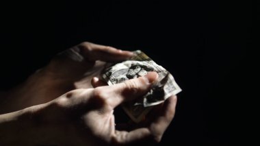 Ekonomik kriz kavramı. Adam buruşmuş dolar banknotlarını açıyor ve onlar da ellerine düşüyor.