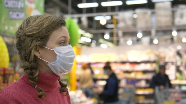 Meisje in beschermende masker wandelingen in supermarkt, bescherming tegen coronavirus pandemie covid-19 — Stockfoto