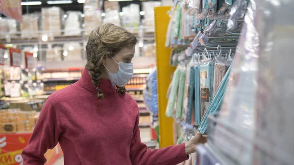 Woman in protective mask walks in supermarket, personal protection coronavirus pandemic covid-19 — Stock Photo, Image