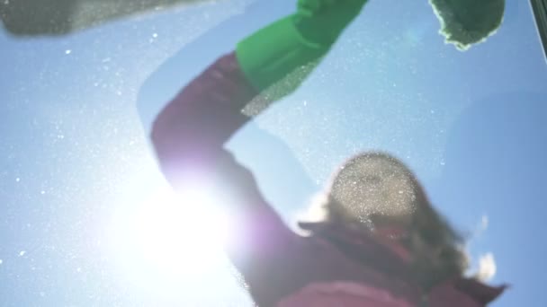 Девушка в зеленых резиновых перчатках моет грязное окно на балконе снаружи, уборка дома — стоковое видео