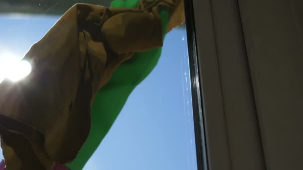 Lány törli foltok és foltok az ablakon közelkép gumikesztyűben az erkélyen — Stock videók