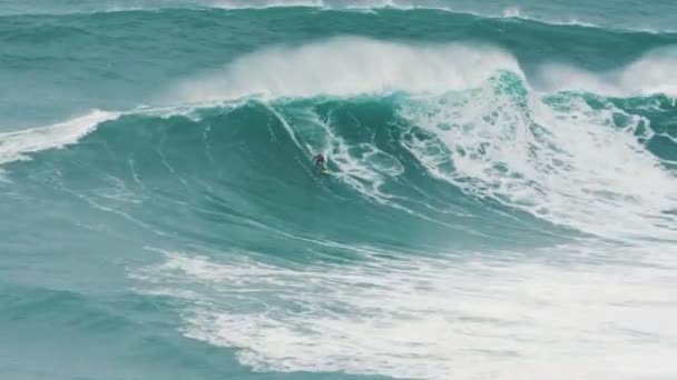 Surfer in gevangen gigantische golf in de Atlantische Oceaan, instructeur begeleidt nabijgelegen op jetski — Stockvideo