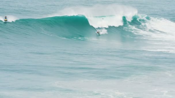 Surfista en chaleco salvavidas rueda en la ola en Portugal, instructor y dron acompaña, cámara lenta — Vídeo de stock