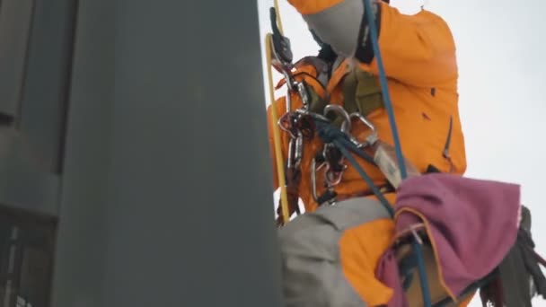 Hoog werk industriële klimmer wast een venster uitzicht door helder glas, slow motion — Stockvideo