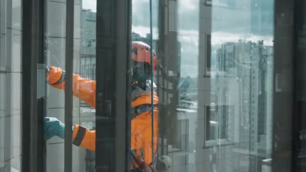 Industrial escalador ventana limpiador espuma vidrio con un abrigo de piel preparación de vidrio para el lavado a gran altitud, cámara lenta — Vídeos de Stock