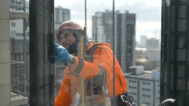 专业的登山者透过玻璃清洗窗户，大型都市建筑的背景特写慢镜头 — 图库视频影像