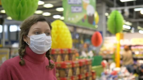 Chica en máscara protectora camina en el supermercado, protección contra la pandemia de coronavirus covid-19 — Vídeos de Stock
