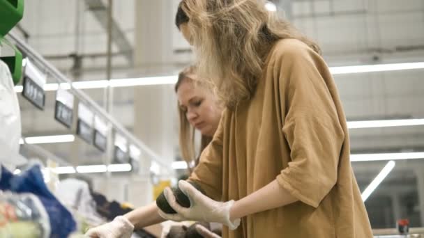 Filles dans des gants médicaux choisissent avocat au supermarché — Video