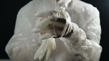 Doktor beyaz koruyucu tulumlar giyip lastik eldiven giyer ve tıbbi maske baş parmak gösteriyor, koronavirüs salgını.