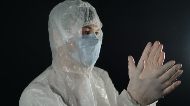 Γιατρός με προστατευτική αντιική στολή και μάσκα χειροκροτεί, καταπολεμά την πανδημία του coronavirus covid-19 — Αρχείο Βίντεο