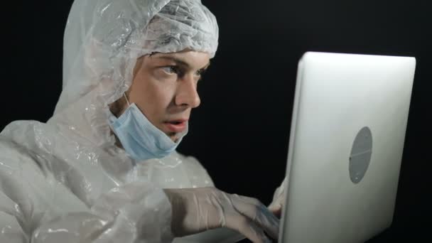 Scienziato in tuta protettiva con laptop in mano sviluppa un vaccino contro il coronavirus pandemico Covid-19 in laboratorio — Video Stock