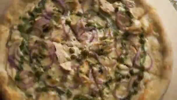 Pizza fresca italiana con pollo e formaggio su una sottile crosta tagliata a pezzi ruota rapidamente su vassoio — Video Stock