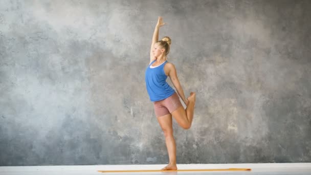 Yoga eğitmeni, stüdyo ağır çekimde halı üzerinde esneme egzersizleri yapıyor. — Stok video