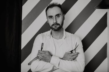 Erkek Kuaför portresi keskin makas ve bıçak tutar. Siyah ve beyaz