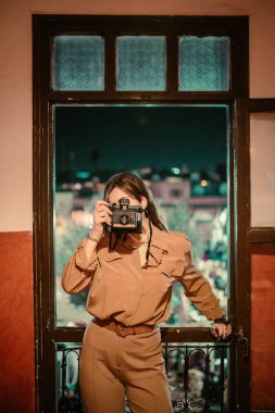 Penceredeki vintage fotoğraf makinesi olan kadın