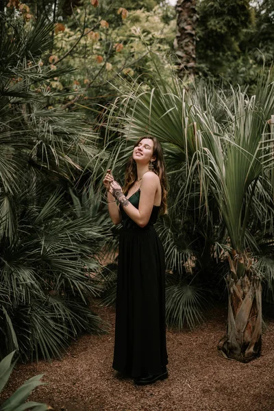 Schöne Frau Mit Schwarzem Kleid Unter Palmen — Stockfoto