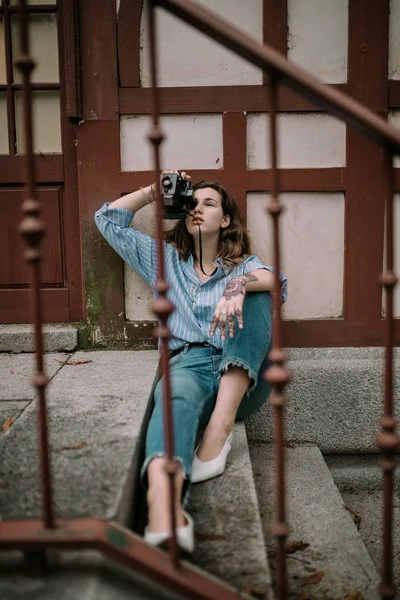 Young woman with instant photo camera. Woman with vintage photo camera