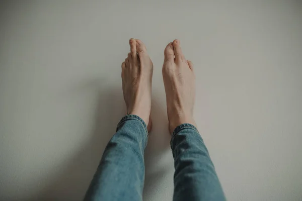 Feet of a man against wall