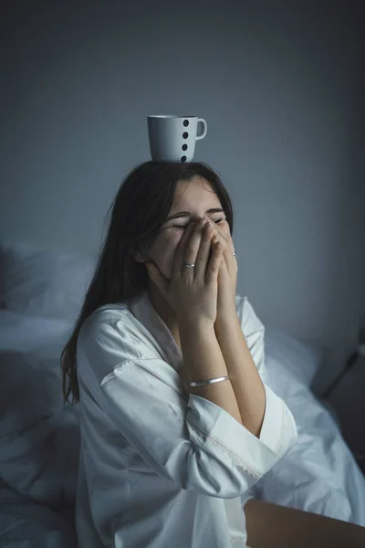 Woman with cup on her head laughing