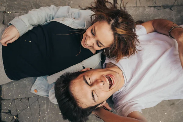 Couple in love lying down laughing. Couple having a good time in the park. Valentine\'s Day