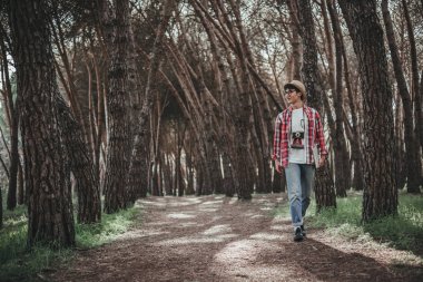 dizüstü bilgisayar ile ormanda yürüyen genç adam