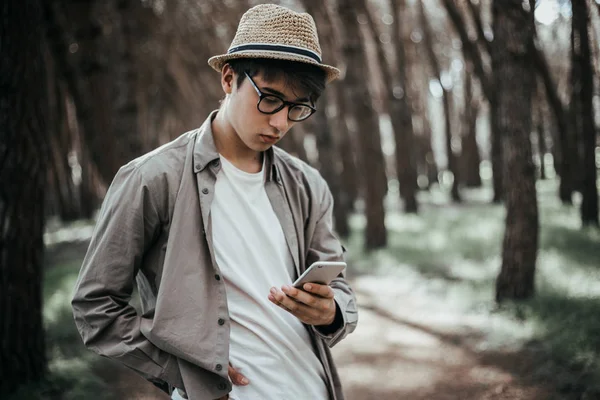 Młody Mężczyzna Kapeluszu Przy Użyciu Telefonu Drewnie — Zdjęcie stockowe