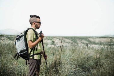Genç backpacker adam, uzun yürüyüşe çıkan kimse