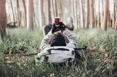 Genç backpacker adam, uzun yürüyüşe çıkan kimse çim üzerinde yalan 