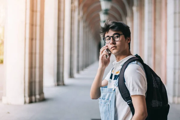 携帯電話を使用してメガネの若い男の屋外のポートレート — ストック写真
