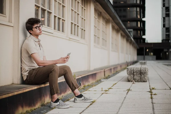 Plenerowej Młody Człowiek Okularach Przy Użyciu Telefonu Komórkowego — Zdjęcie stockowe