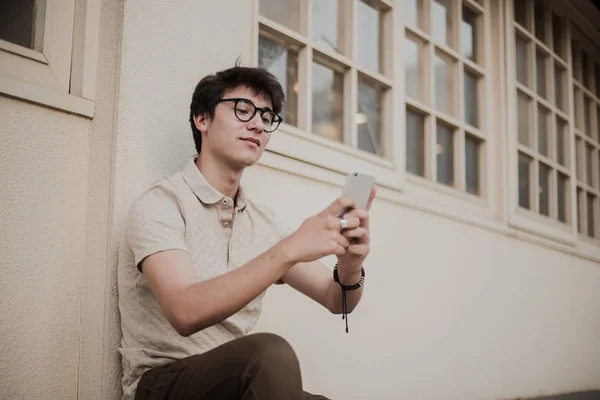 Plenerowej Młody Człowiek Okularach Przy Użyciu Telefonu Komórkowego — Zdjęcie stockowe
