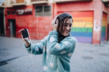 Kulaklık ile müzik dinlemek ve sokağın ortasında bir selfie alarak güzel kadın