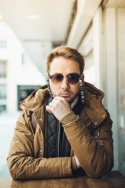 genç adam açık havada poz güneş gözlüğü takıyor 