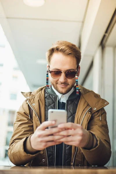 Młody Człowiek Nosi Okulary Pozowanie Zewnątrz Przy Użyciu Smartfona — Zdjęcie stockowe