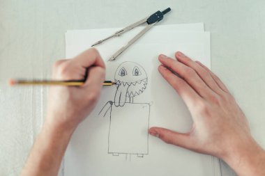 El Sanatları Atölyesi çalışma erkek tasarımcısında. Genç tasarımcı masanın üzerinde çizim