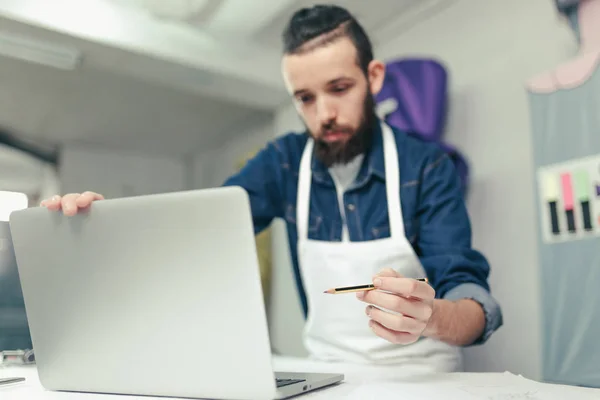 Jeune Artisan Hipster Pointant Vers Écran Ordinateur Dans Atelier Artisanat Photo De Stock