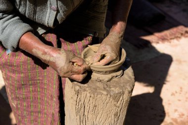 Kapalı yaşlı kadın çömlekçi elleri çömlekçi tekerleği olmadan kilden kase yapıyor.