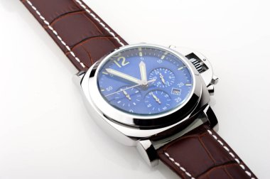 Mavi kadranlı lüks moda saati ve beyaz arka planda kahverengi timsah derisi deri saat bandı.