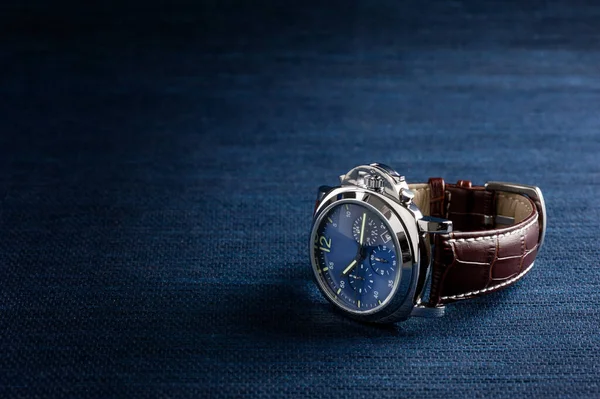 luxury fashion watch with blue dial and brown crocodile grain leather watch band