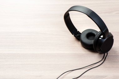 Kablolu siyah kulaklık ahşap arka planda izole