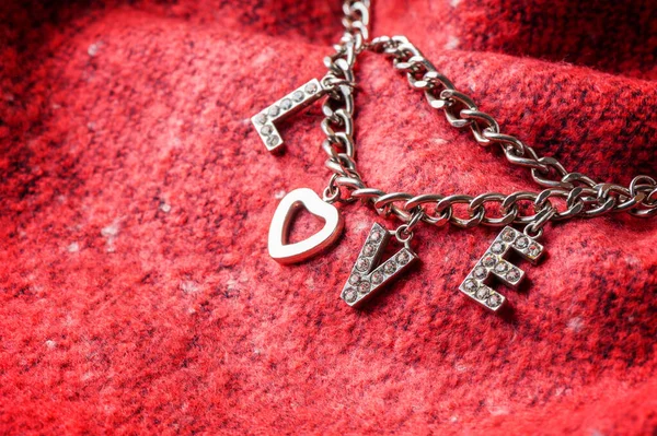 爱情这个词是从女人的饰物 金属链 心形和钻石 中提取出来的 — 图库照片