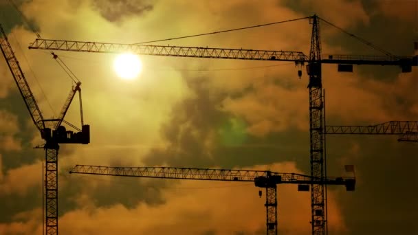 Time lapse of construction cranes silhouettes at sunset light build develop — Stock Video