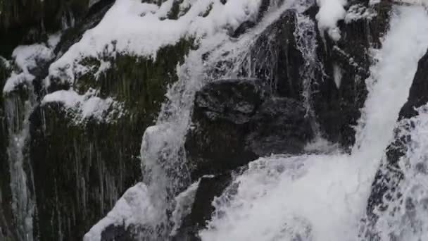 Zeitraffer eines rauschenden Wasserfalls, der eisige Felsen hinunterstürzt — Stockvideo