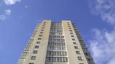 Açık mavi gökyüzüne karşı yüksek binalar. Gelişmekte olan ülkelerdeki modern binalar. Bina geniş pencereli soluk sarıdır. İnsansız bir bina. Şehirde karantina.