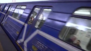 Metro treni platforma varır ve durur. Mavi metro araçları hızla geçer. Metropolitan bölgelerinde toplu taşıma. Şehirde büyük trafik sıkışıklığı var. Kişisel ulaşımın reddedilmesi.