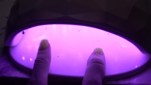 把钉子放在紫外线灯里晒干 涂上指甲油后擦干你的指甲油 关心的钉子 女人的手的美丽 — 图库视频影像