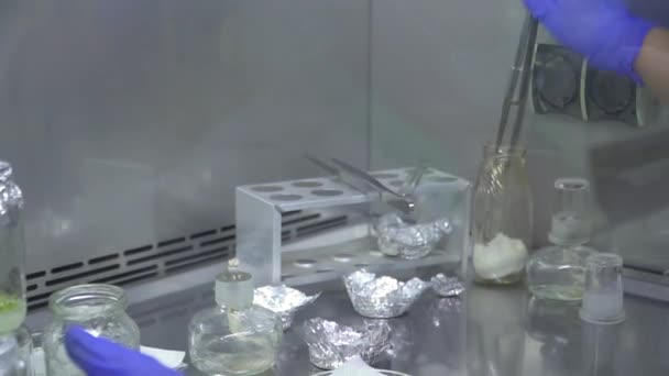 Le spécialiste plonge les pinces dans un tube à essai, puis les amène au brûleur. Brucelles brûlantes. Bleuets .