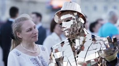 MINSK, BELARUS - 15 Haziran 2019: Altın takım elbiseli bir animatör bir kadınla fotoğraflandı. Mezuniyeti kutlamak için parti..