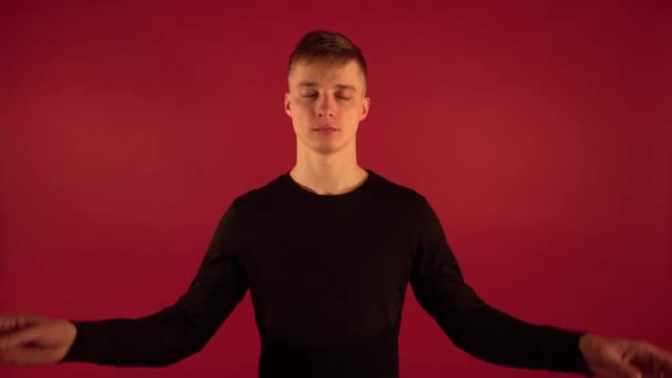 Magabiztos Fickó Fekete Pólóban Jóga Gyakorlatokat Végez Vörös Háttérrel Tudatosság — Stock videók