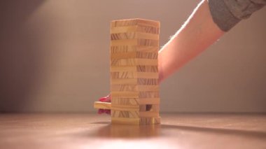 Masa oyunları. Bir çift Jenga adında bir masa oyunu oynuyor. Karantinadaki insanların eğlencesi. Evdeki basit ve ilginç oyunlar.